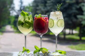 Refreshing summer cocktails with a slice of lime. Alcoholic drink. Garnished with a sprig of mint,...
