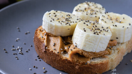 fast food, snack, peanut butter and banana sandwich with chia seeds on a plate