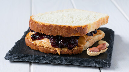 fast food, snack, sandwich with peanut butter and fruit jam on a white wooden table