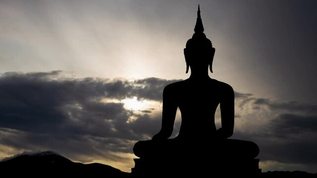 Buddah: Time Lapse at Sunrise with Fast Clouds and Dark Silhouette of Antique Statue , Bangkok, Thailand