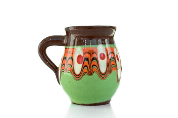 Close up cute pot with colorful painting, green orange brown clay jar with handle, traditional bulgarian decoration souvenir. Pottery, earthenware, classic hand crafted activity. White background.  