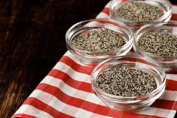 Glass bowl with chia seeds on wooden table