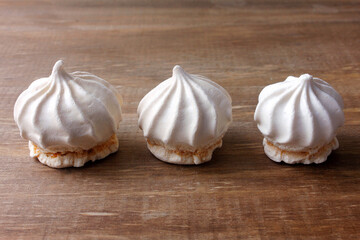 sigh or homemade meringue is a sweet made from egg whites, sugar and lemon on the rustic kitchen wooden table