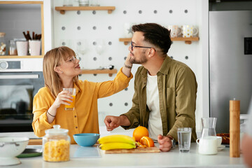 Young couple eating breakfast at home. Boyfriend and girlfriend enjoying in the morning..	