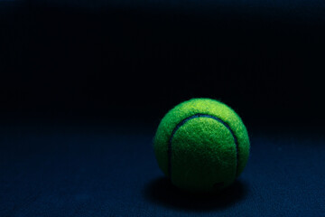 tennis ball isolated on dark background in hard light