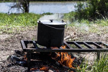 Cooking in a pot over an open fire during a hike.