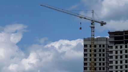 Fototapeta na wymiar Building houses. Tower crane on the construction site of a high-rise building.