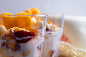 delicious melted natural ice cream or cold youghurt desert with tropical fresh fruits on the light rustic background