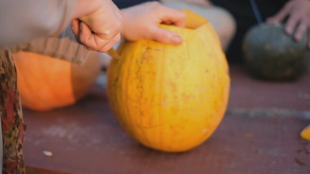 Preparing for the holiday Halloween. Cutting a pumpkin with a knife.