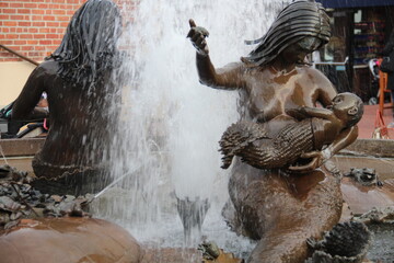 Fototapeta na wymiar Mother child statue in the fountainside.