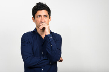 Portrait of Hispanic businessman thinking and looking up