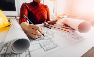 Two colleagues discussing data working and tablet, laptop with on on architectural project at construction site at desk in office