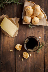 Cup of coffee with cheese bread basket and slice of cheese on rustic wooden table top view