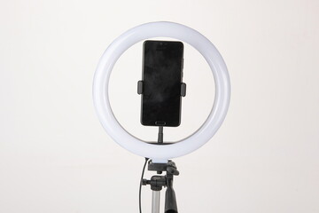 The camera fill light for the phone is mounted on a tripod, which is a device for shooting vlogs and doing live broadcasts.