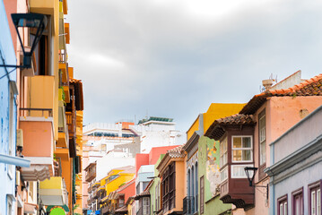 Fototapeta premium Colorful buildings with a wooden balconies on a street in spanish town Puerto de la Cruz on a sunny day, Tenerife, Canary islands, Spain.