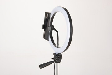 Obraz premium The camera fill light for the phone is mounted on a tripod, which is a device for shooting vlogs and doing live broadcasts.