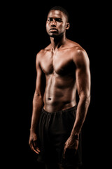 Fototapeta na wymiar Bare chested black fitness man looking at camera wearing sport short trousers