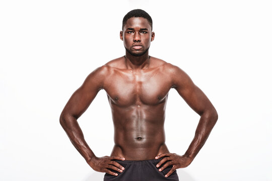 Bare Chested Black Fitness Man Looking At Camera Wearing Sport Short Trousers And Posing His Hands On His Hips