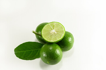 Thai lemons are placed in front of the fruit cluster and separated from a white background.
