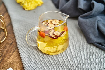 A hot chrysanthemum drink with goji berries and sliced dates in it.