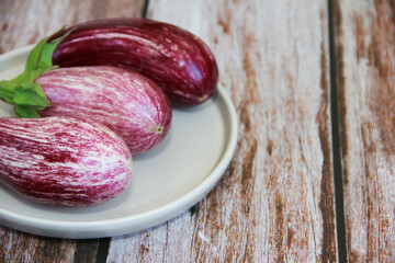 natural striped eggplant fruits on a decorative plate