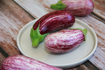 natural striped eggplant fruits on a decorative plate