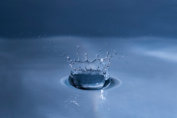 Splashing water drop hitting water surface