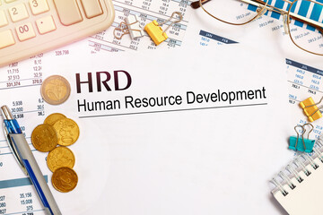 Desktop office desk, notebook, glasses, pen and documents with inscription HRD Human Resource Development