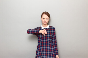 Portrait of disappointed girl showing thumb down gesture of dislike