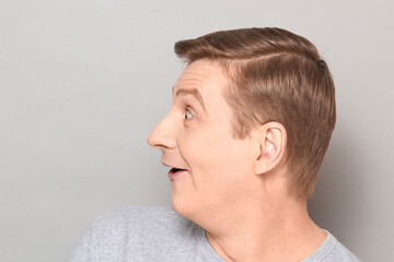 Fototapeta premium Portrait of funny happy impressed man with widened eyes and open mouth