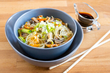 Funchosa with mushrooms, carrots, onions and peppers. Serving dishes with soy sauce