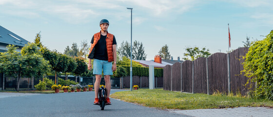 Young Man Riding On Electric Unicycle (EUC) On Street, Best Mobile Portable Personal Transportation Vehicle, Summer Day © toyechkina