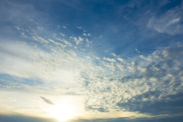 sparkle low sun on a blue cloudy sky, beautiful sunset background