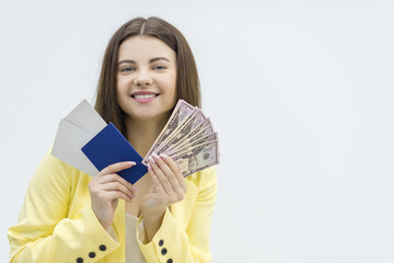 Travel budget concept. Happy woman holds bundle of money and travel documents ready to start an exiting tour.