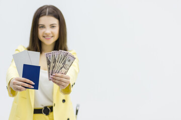 Travel budget concept. Happy woman holds bundle of money and travel documents ready to start an exiting tour.