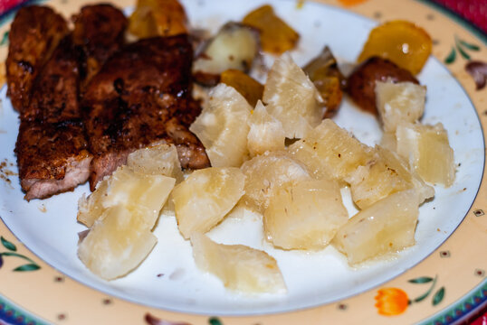 Dish with steaks cooked in a pan with onions, Andean potatoes, fine herbs and spices, accompanied with cassava in brine. Selective focus.