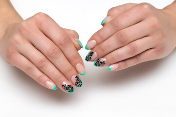 mint french manicure with black painting, silver crystals on short sharp nails on a white background close-up