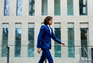 Handsome businessman in a suit walking through the city to work.