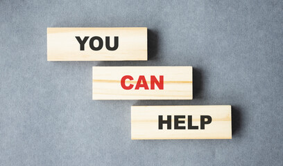 We can help - phrase on wooden blocks with letters, mutual assistance companionship concept.