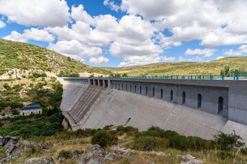 Fototapeta na wymiar Reservoir dam a sunny day of summer. Las Navas del Marques, Avila, Spain.