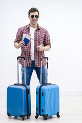 Overjoyed boy with suitcases and travel documents is eager to discover new destination and feelings.