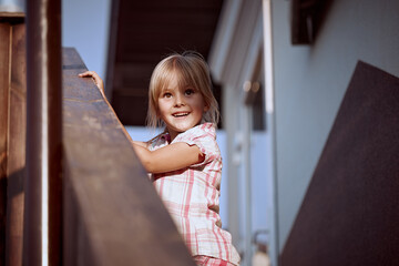 Beautiful little girl blonde plays on the porch