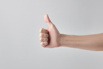 showing thumb up or like gesture. caucasian male person in casual cloth isolated over gray background. copy space. studio shot. approve symbol.