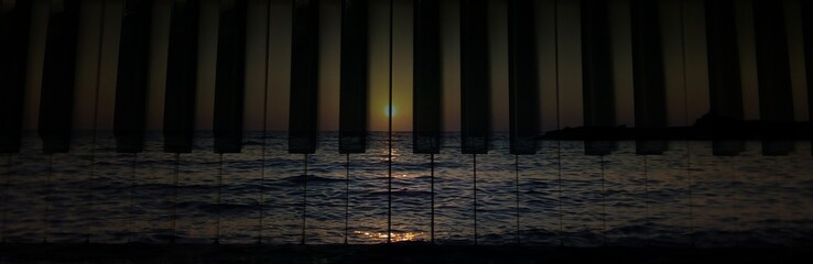 Sunset over the ocean seen through the piano tiles © Georgios Kalogeropoulos/Wirestock