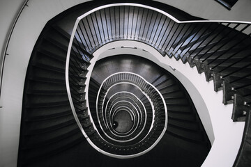 looking deep into long spiral stair case of big building