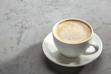 white cup of coffee with Latte art on concrete table