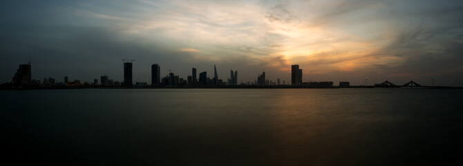 A panoramic view of Bahrain skyline at dusk with dramatic cloud