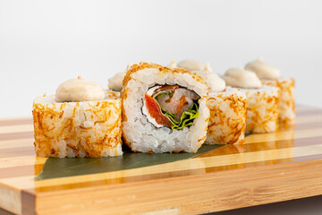 Maki Sushi Rolls set on wooden bamboo board. Japanese traditional Cuisine. White background.