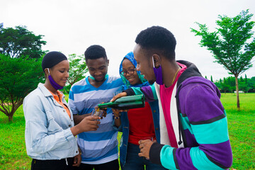 young black people standing in a park and pouring drinks into their glass cups