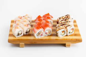 Maki Sushi Rolls set on wooden bamboo board. Japanese traditional Cuisine. White background.